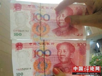 上图为此次发现的“C1F9”假币：人物面部泛白，水印发黑。下图为人民币百元面额真币：人物面部红润，水印发亮。新京报记者 李宁 摄